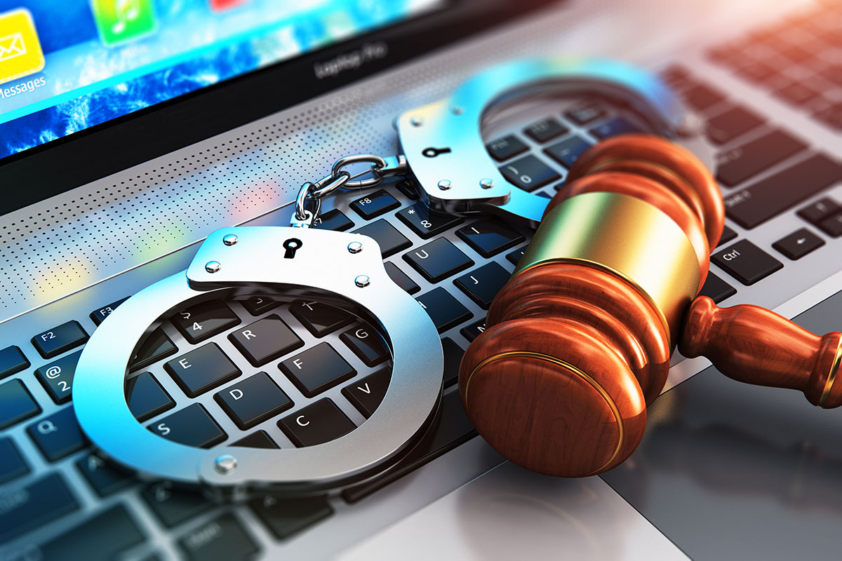 Gavel and handcuffs on computer keyboard
